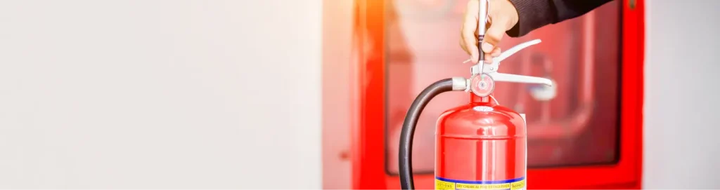 Fire extinguisher mounted on wall inside safety cabinet